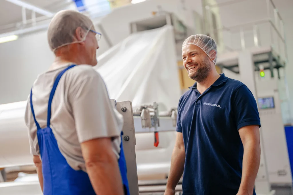 Mitarbeiter In Der Produktion Jpg zwei Mitarbeiter reden miteinander